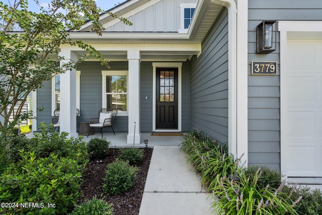 view of exterior entry with a porch