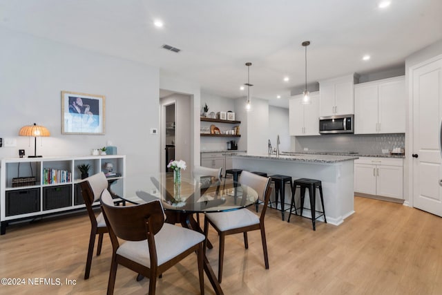 dining area featuring light hardwood / wood-style floors and sink