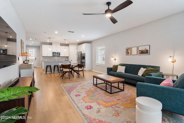 living room with ceiling fan and light hardwood / wood-style floors