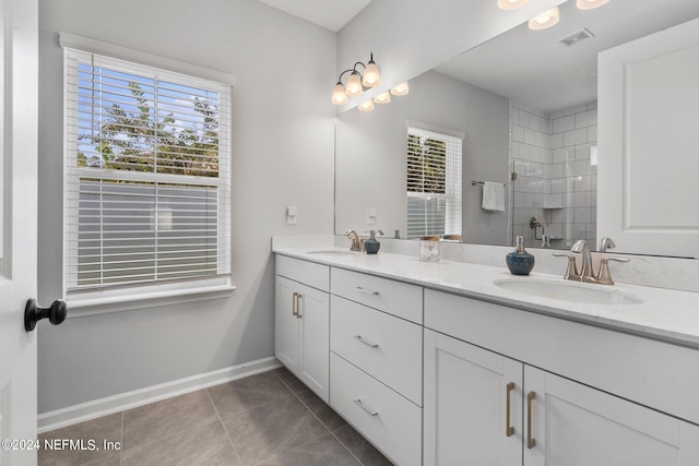 bathroom featuring tile patterned flooring, vanity, and walk in shower