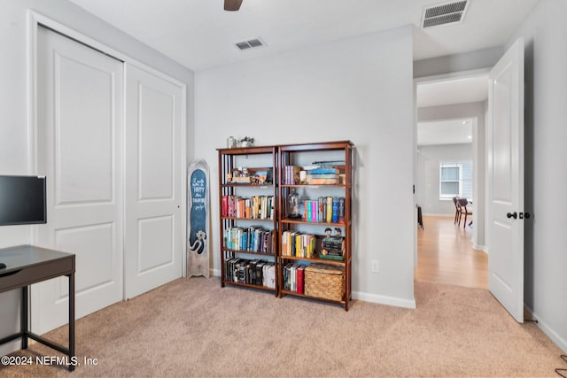 carpeted home office featuring ceiling fan