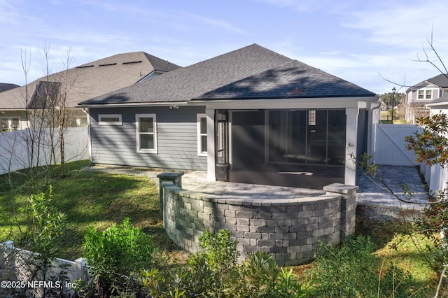 rear view of property featuring a sunroom and a yard