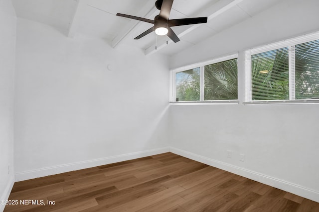 spare room with vaulted ceiling with beams, ceiling fan, plenty of natural light, and wood-type flooring