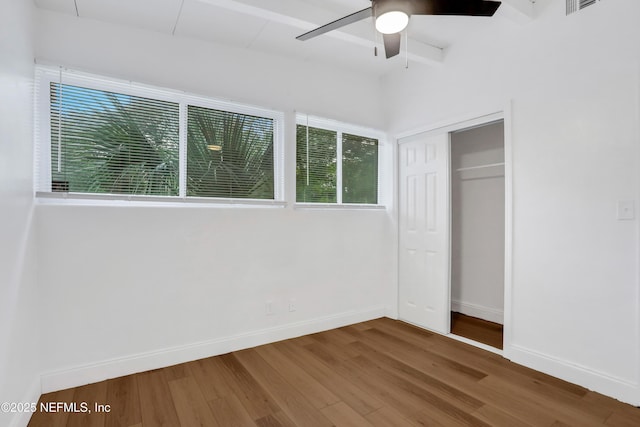 unfurnished bedroom with ceiling fan, a closet, and hardwood / wood-style flooring