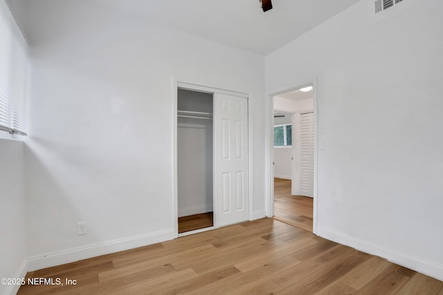 unfurnished bedroom featuring ceiling fan, a closet, and light hardwood / wood-style flooring