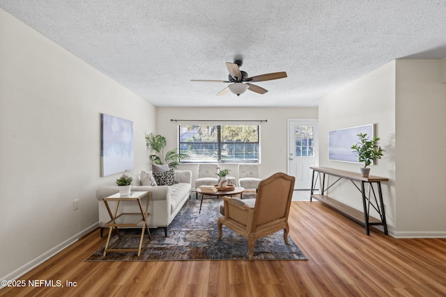 sitting room with ceiling fan, a textured ceiling, and hardwood / wood-style flooring