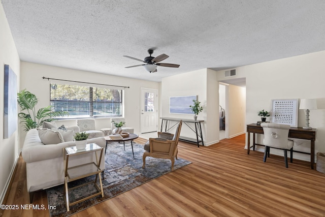 living room with wood-type flooring, a textured ceiling, and ceiling fan