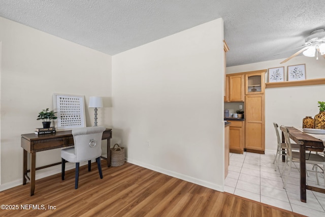 office space featuring a textured ceiling, ceiling fan, and light hardwood / wood-style flooring