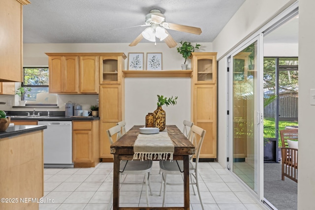 kitchen with white dishwasher, light tile patterned floors, a textured ceiling, and light brown cabinets