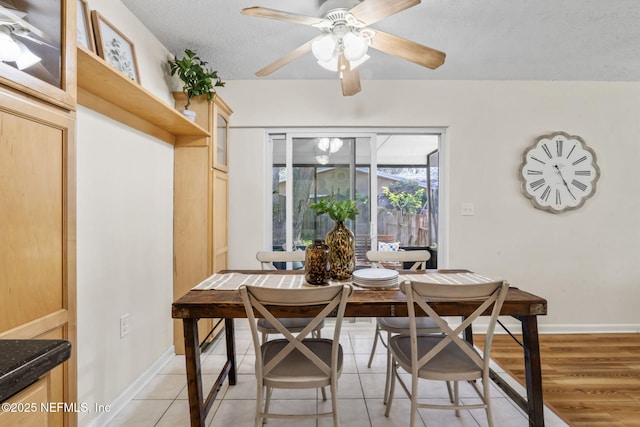 dining space featuring a textured ceiling, light tile patterned flooring, ceiling fan, and breakfast area