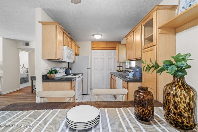 kitchen with sink, white appliances, and light brown cabinetry