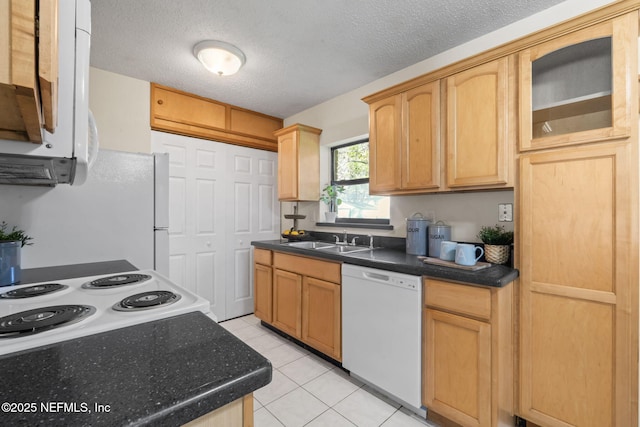 kitchen featuring sink, white appliances, a textured ceiling, and light brown cabinetry