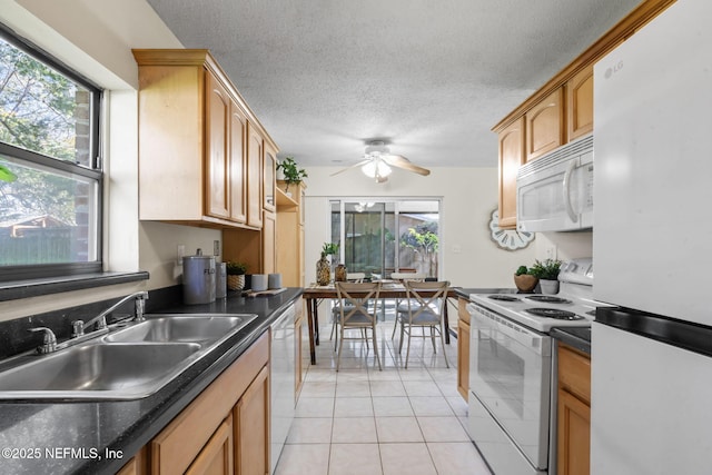 kitchen with sink, white appliances, light tile patterned flooring, ceiling fan, and a healthy amount of sunlight