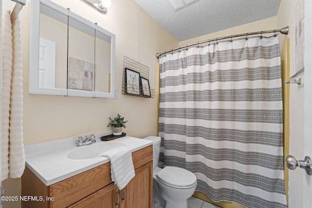 bathroom with a textured ceiling, curtained shower, vanity, and toilet