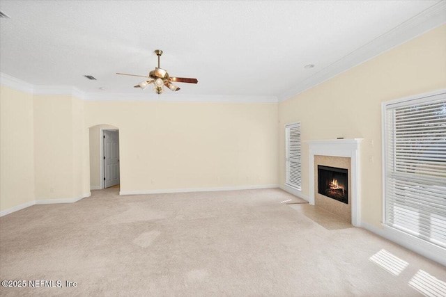 unfurnished living room featuring ceiling fan, light colored carpet, and ornamental molding