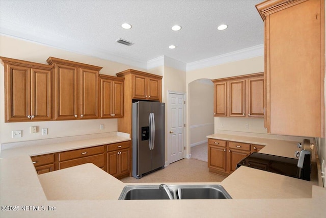 kitchen with a textured ceiling, stainless steel appliances, ornamental molding, and sink