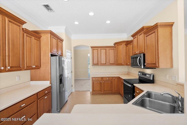 kitchen with appliances with stainless steel finishes, a textured ceiling, ornamental molding, and sink