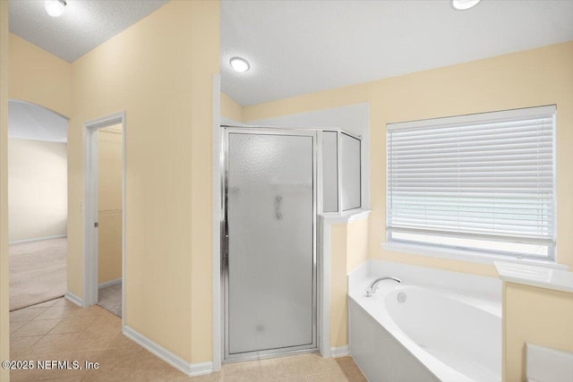 bathroom featuring tile patterned floors, a textured ceiling, and shower with separate bathtub