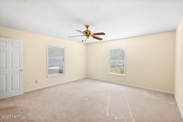 carpeted spare room with ceiling fan and a textured ceiling