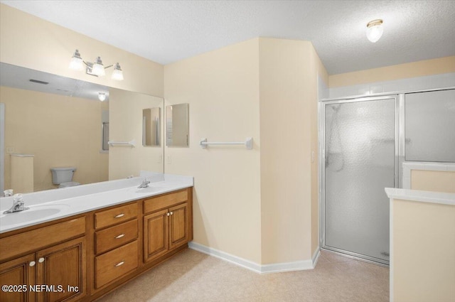 bathroom with toilet, vanity, a textured ceiling, and walk in shower