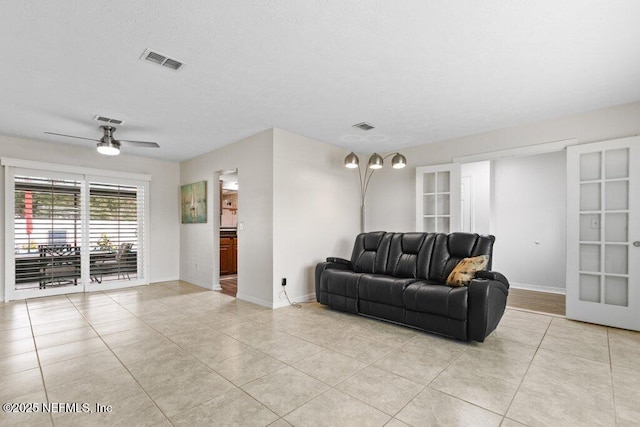 living room with ceiling fan, light tile patterned flooring, and french doors