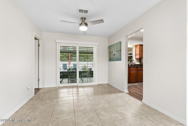 tiled empty room featuring ceiling fan