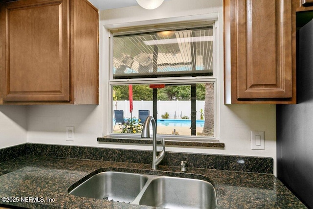 kitchen featuring dark stone countertops and sink