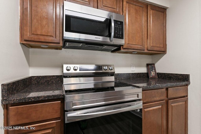 kitchen featuring appliances with stainless steel finishes and dark stone countertops