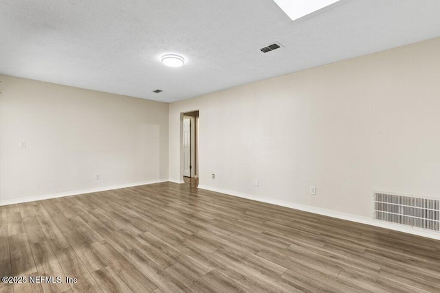 spare room featuring hardwood / wood-style floors and a textured ceiling