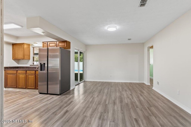 kitchen featuring stainless steel fridge with ice dispenser, light hardwood / wood-style floors, and sink