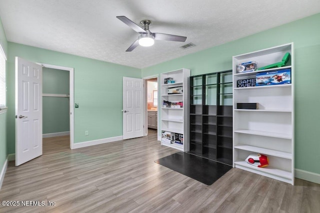 bedroom with ceiling fan, a textured ceiling, and hardwood / wood-style flooring