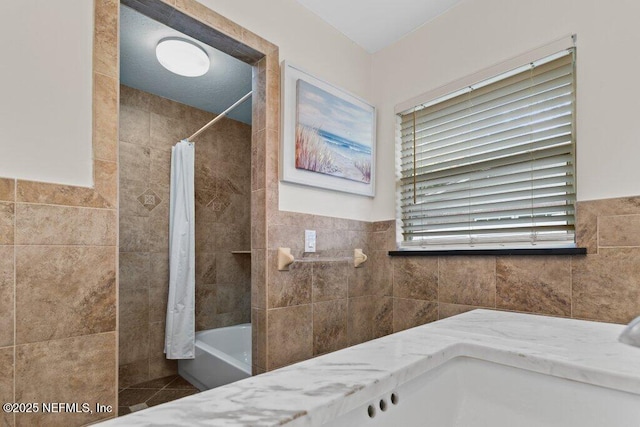 bathroom with shower / bath combination with curtain and tile walls