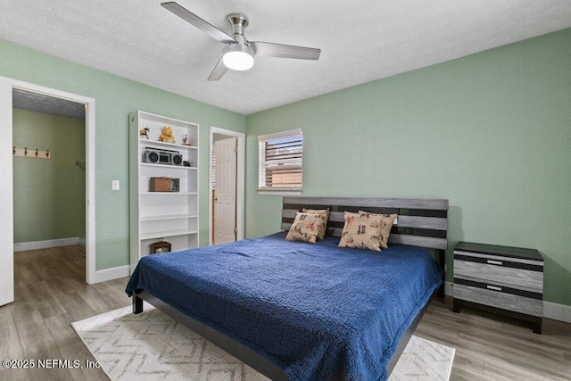 bedroom featuring a textured ceiling, hardwood / wood-style flooring, and ceiling fan