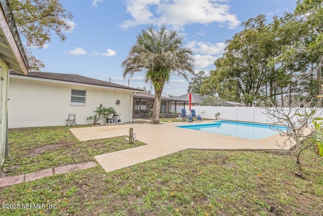 view of pool with a patio area and a lawn