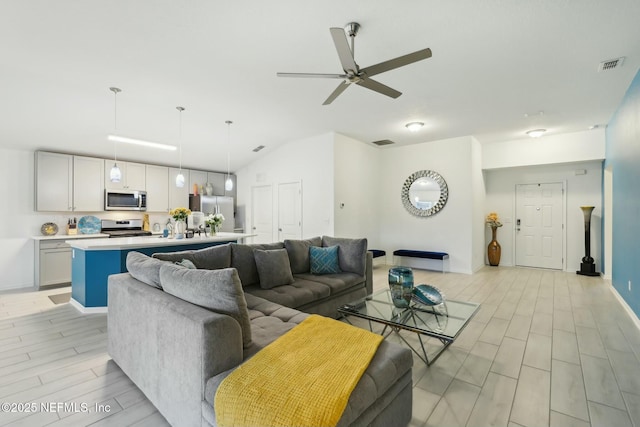 living room featuring ceiling fan and lofted ceiling