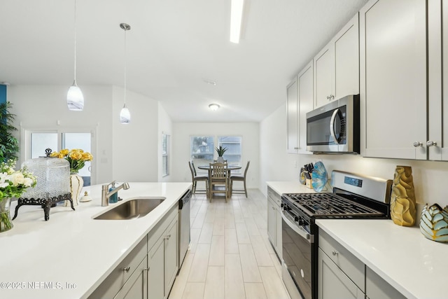 kitchen with a healthy amount of sunlight, appliances with stainless steel finishes, pendant lighting, and sink