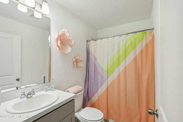 bathroom with toilet, vanity, a textured ceiling, and curtained shower