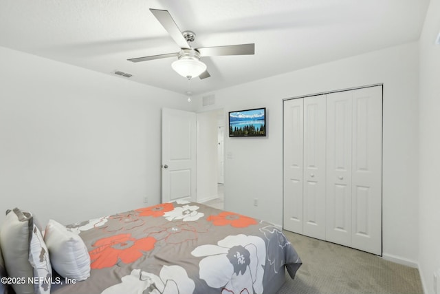 carpeted bedroom featuring ceiling fan and a closet