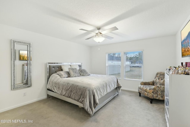 carpeted bedroom with ceiling fan and a textured ceiling