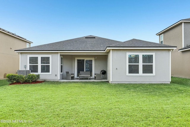 rear view of house featuring central AC unit, a yard, and a patio