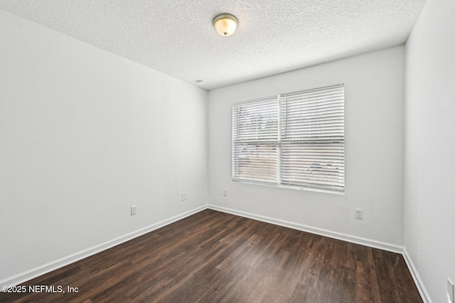 unfurnished room with dark wood-type flooring and a textured ceiling