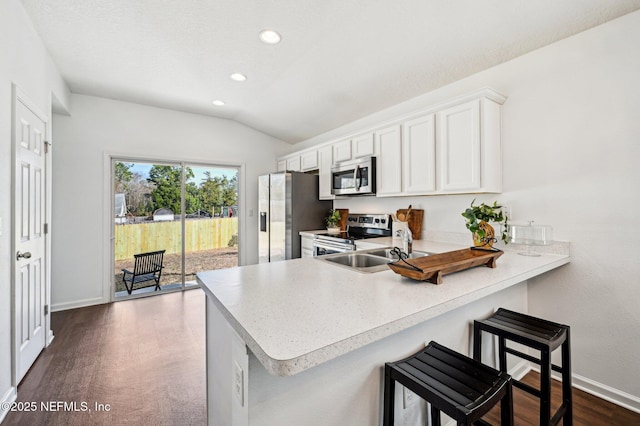 kitchen with stainless steel appliances, white cabinetry, a breakfast bar area, and kitchen peninsula