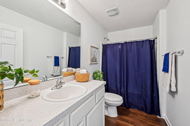 bathroom with toilet, a textured ceiling, vanity, a shower with shower curtain, and hardwood / wood-style flooring