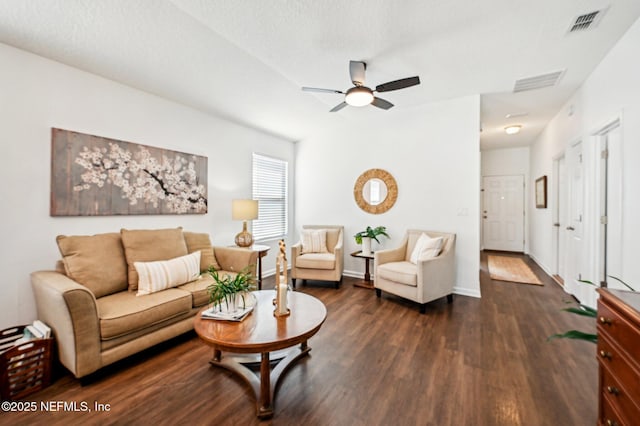 living room featuring ceiling fan, dark hardwood / wood-style flooring, and a textured ceiling