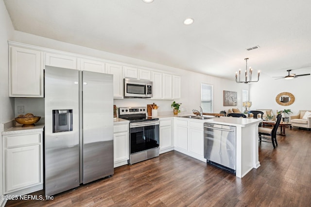 kitchen with white cabinetry, hanging light fixtures, stainless steel appliances, and kitchen peninsula