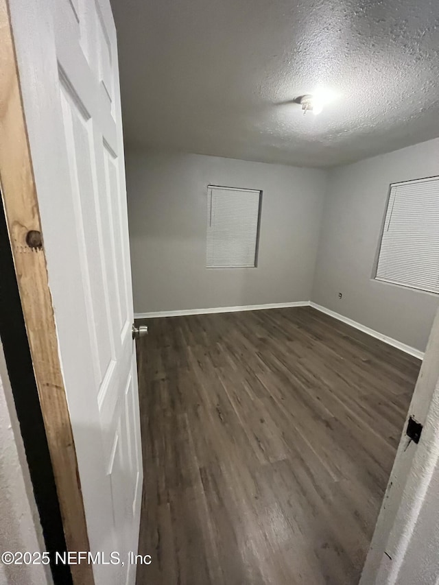 empty room featuring dark hardwood / wood-style flooring and a textured ceiling