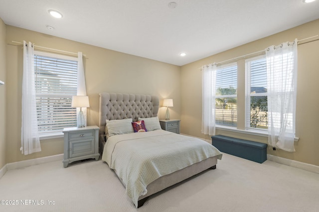 bedroom with multiple windows and light colored carpet