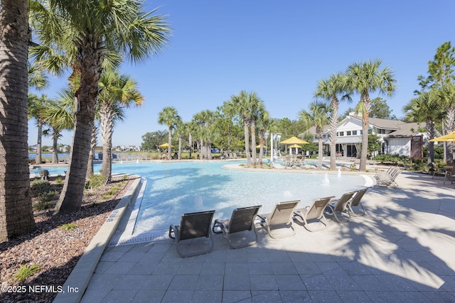 view of pool featuring pool water feature and a patio