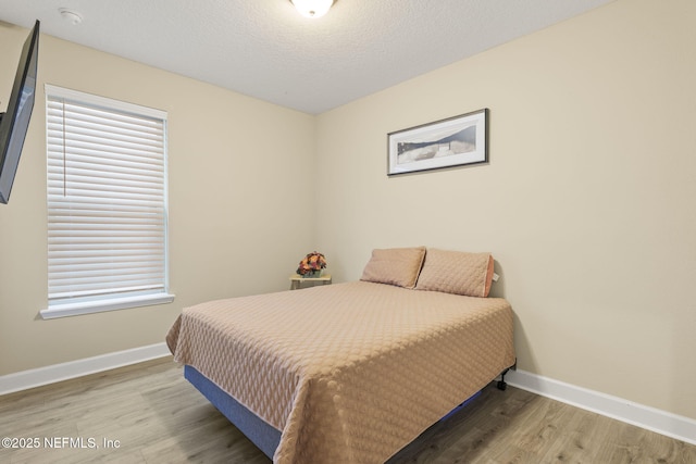 bedroom with hardwood / wood-style flooring and a textured ceiling