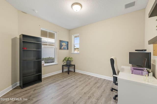 office space with a textured ceiling and light wood-type flooring